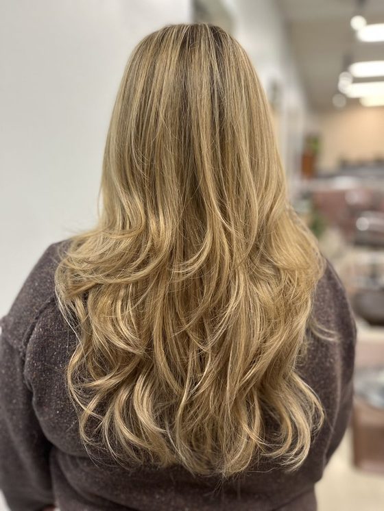Hair colored from dark roots into blonde ends.