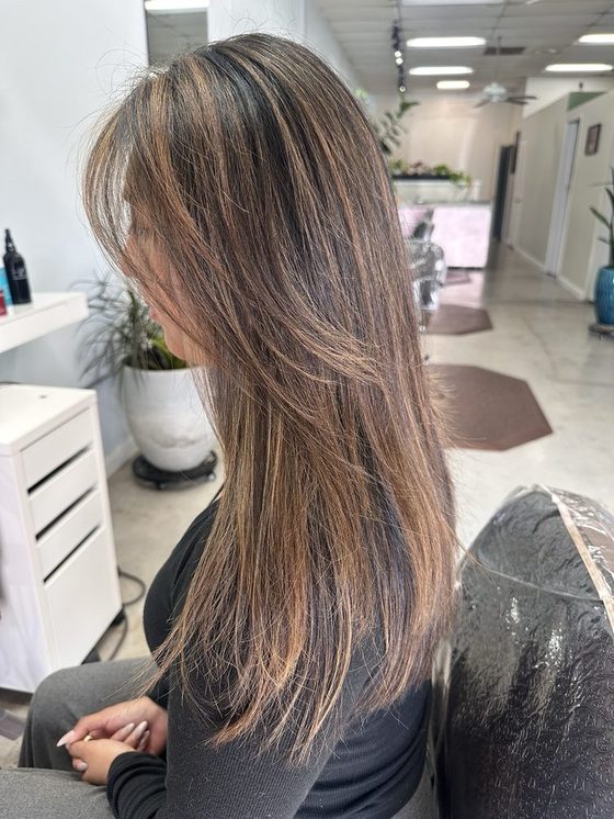 Long hair blown out straight and smooth after a smoothing treatment.